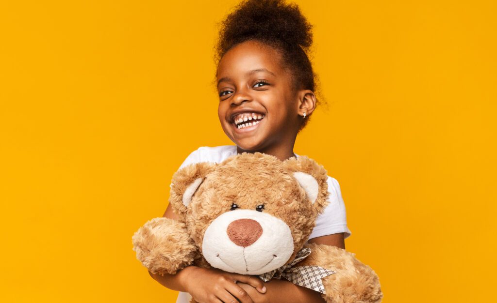 Girl happily embracing teddy bear